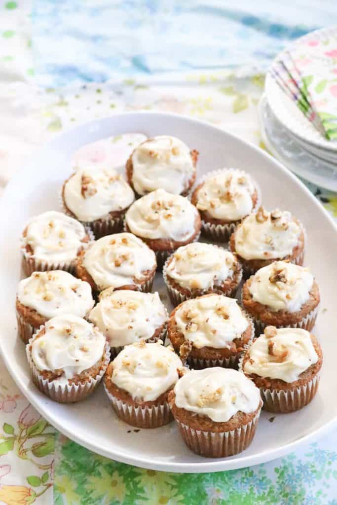 Banana Bread Mini Muffins on a platter with plates and napkins beside.