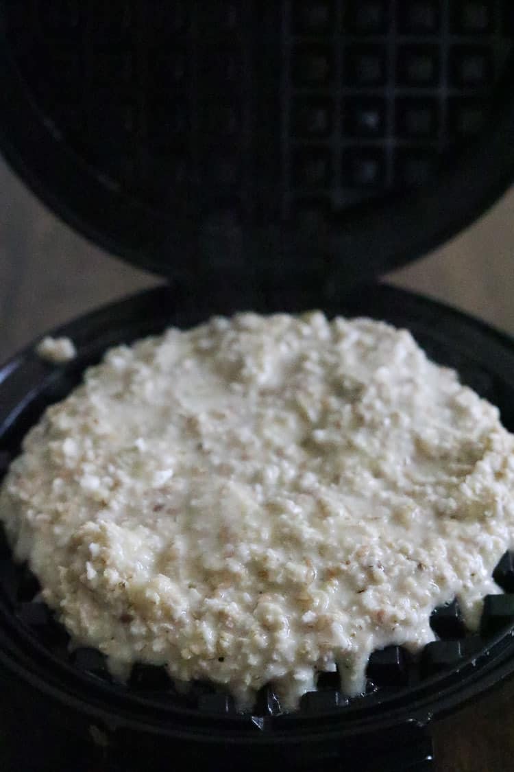 overhead shot of vegan waffle batter spread out on waffle iron surface