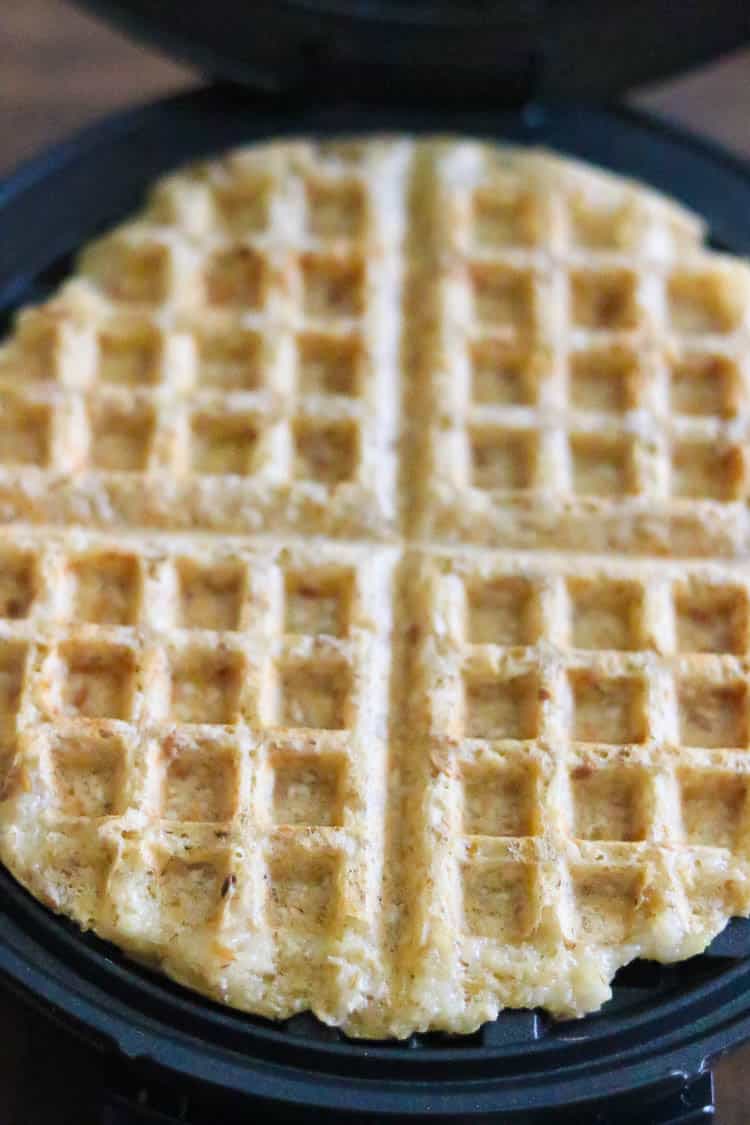 overhead shot of lightly browned vegan waffle in opened waffle iron