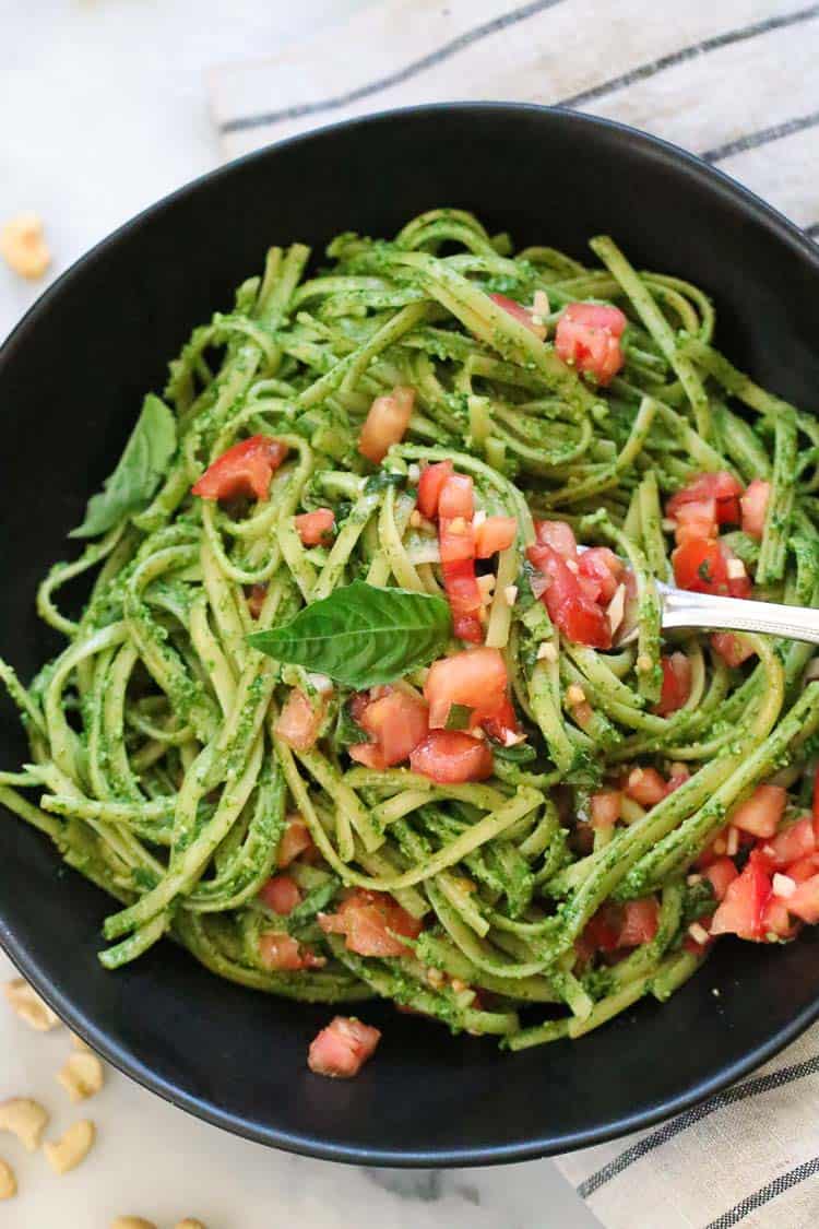 Vegan pesto pasta in a black bowl.