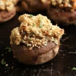 side overhead photo of stuffed vegan mushroom with chopped fresh herbs