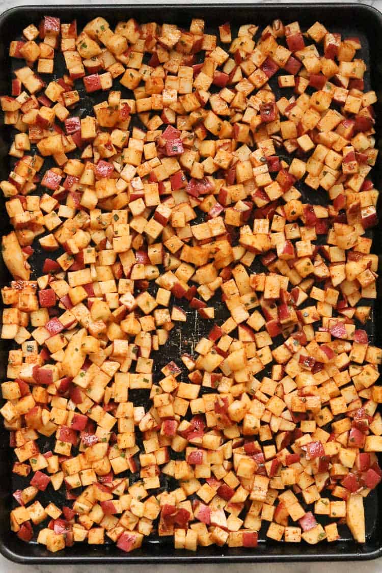 overhead shot of uncooked breakfast potatoes on a baking tray