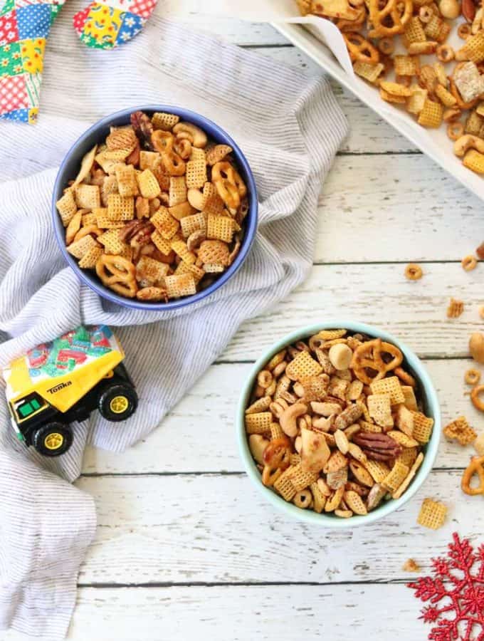 Overhead shot of vegan chex mix in blue bowls with napkin beside