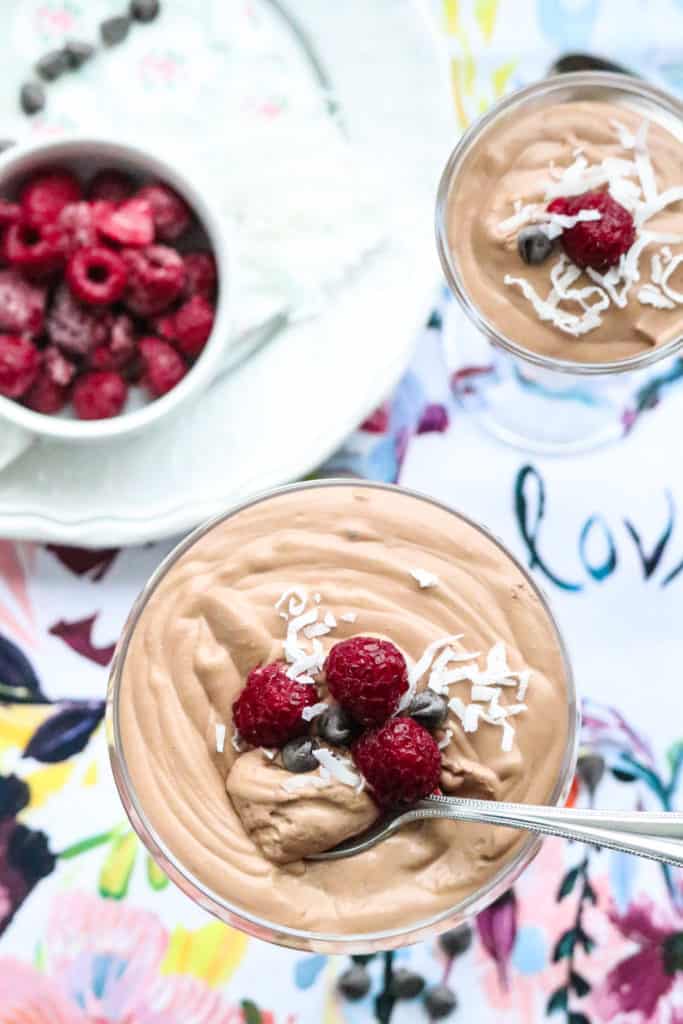 Overhead view of Vegan Chocolate Mousse in glasses with garnish of raspberries.