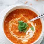 Savory Red Lentil and Chickpea Soup with a swirl of vegan yogurt and garnish of cilantro!
