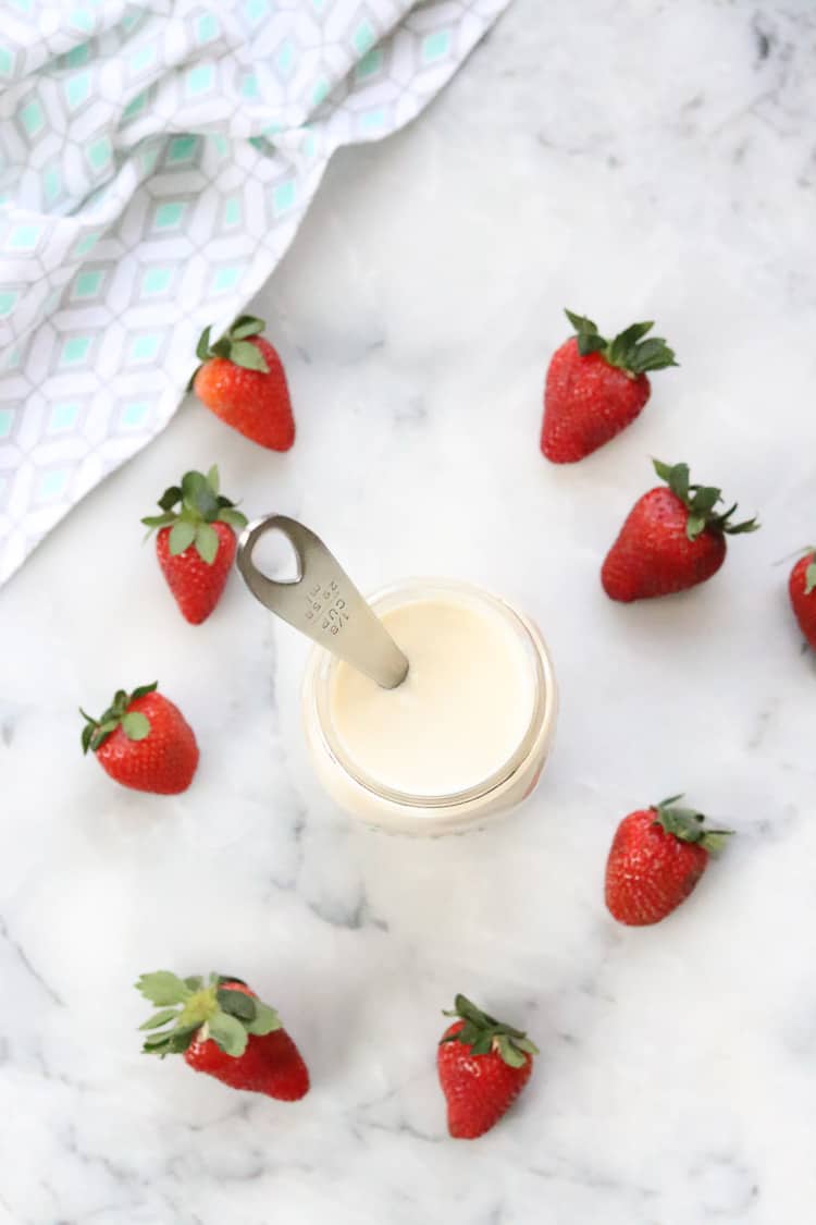overhead shot of vegan yogurt in a jar surrounded by strawberries