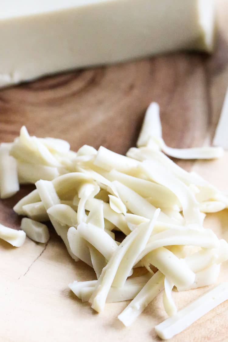 vegan mozzarella shredded on a wood board