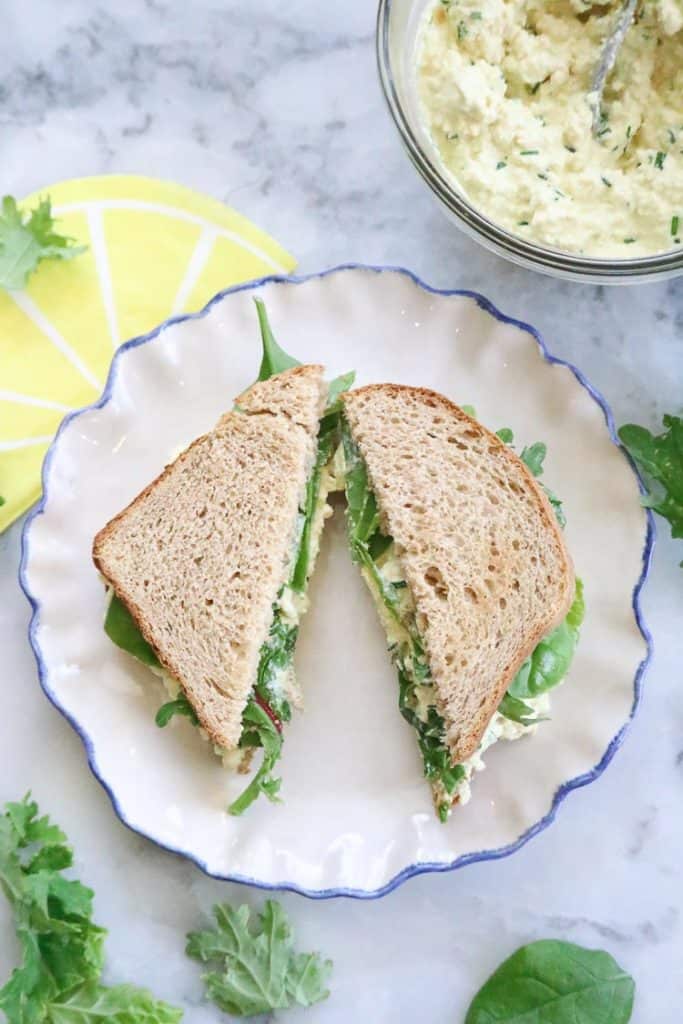 Over head view of Vegan Egg Salad sandwich cut on a plate.