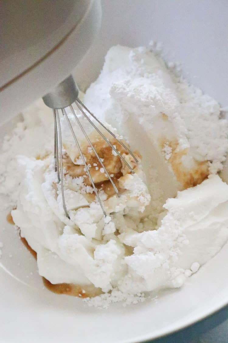 over head shot of beaters in a bowl with ingredients for coconut whip cream.