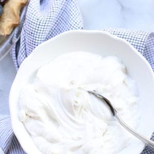 Overhead shot of Easy Vegan coconut whip cream piled in a bowl with a napkin background