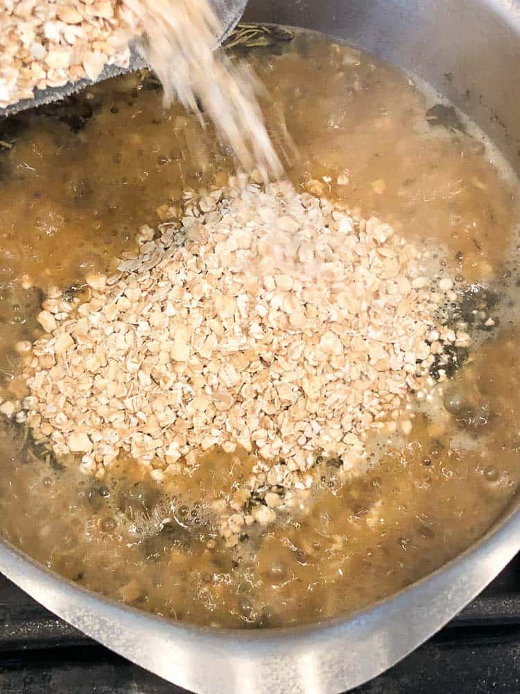 Overhead shot of pouring oats into pot of mixture for vegan oatmeal burger