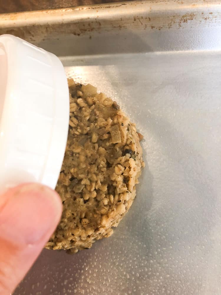 overhead shot of placing shaped vegan oatmeal burger on a tray