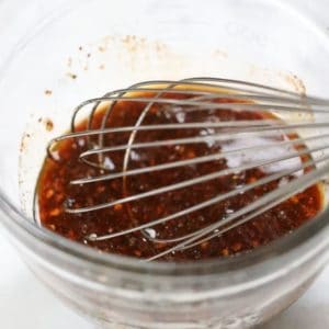 Bowl of jerky seasoning sauce in a bowl with a whisk
