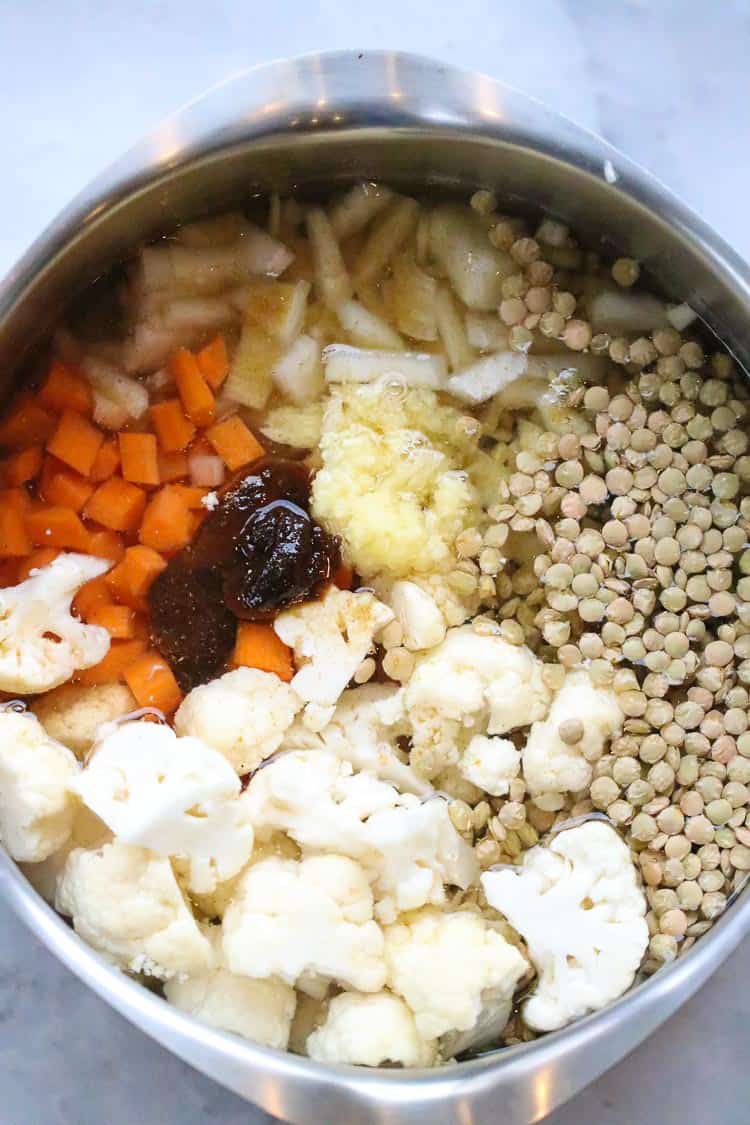 overhead shot of seasonings added to lentil soup pot