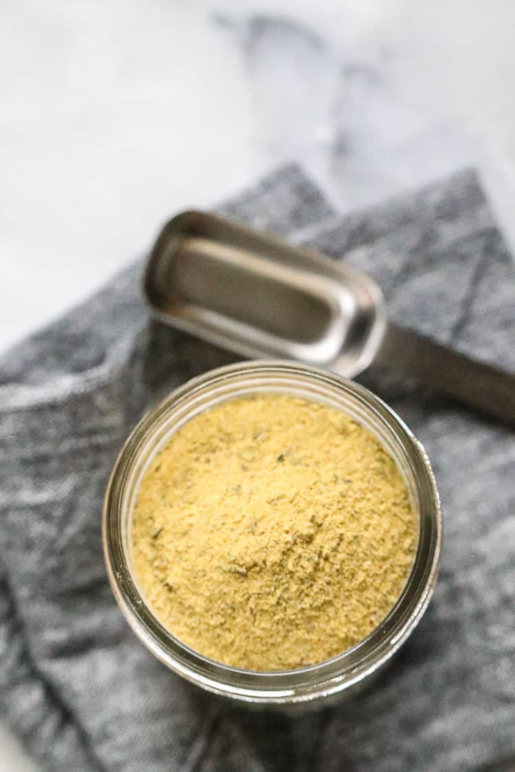 overhead shot of vegan chicken-like seasoning in a small clear jar on top of gray napkin