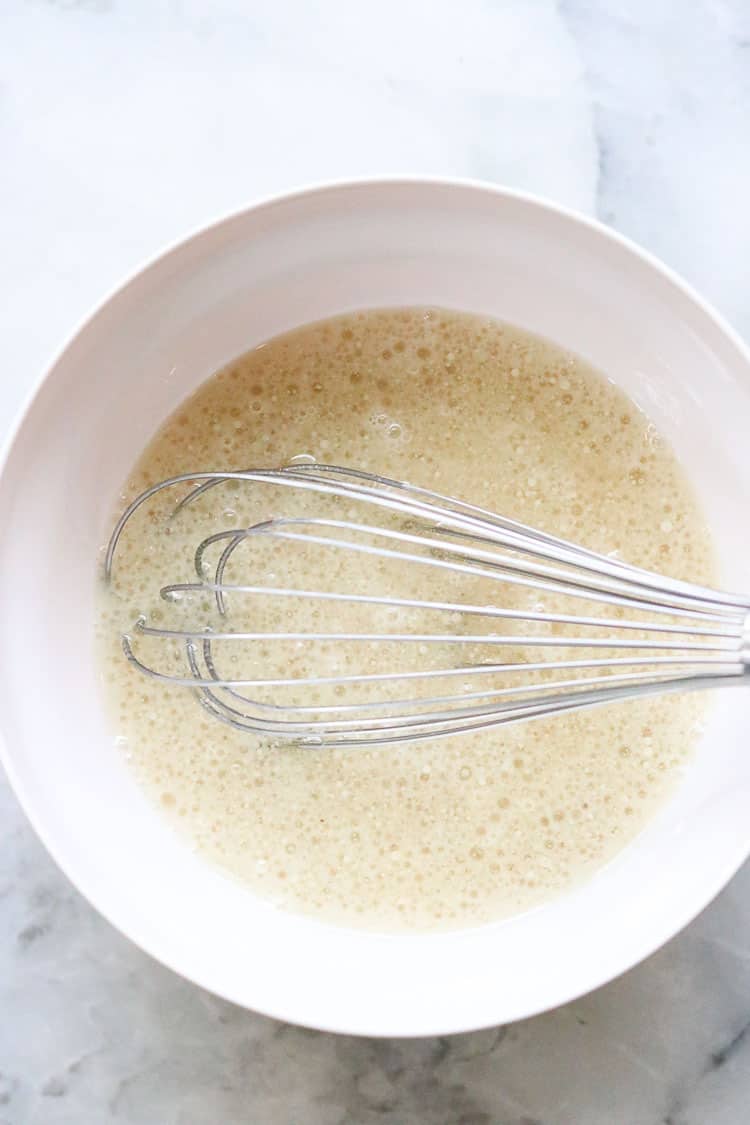 overhead view of wet ingredients for vegan cornbread in a white mixing bowl