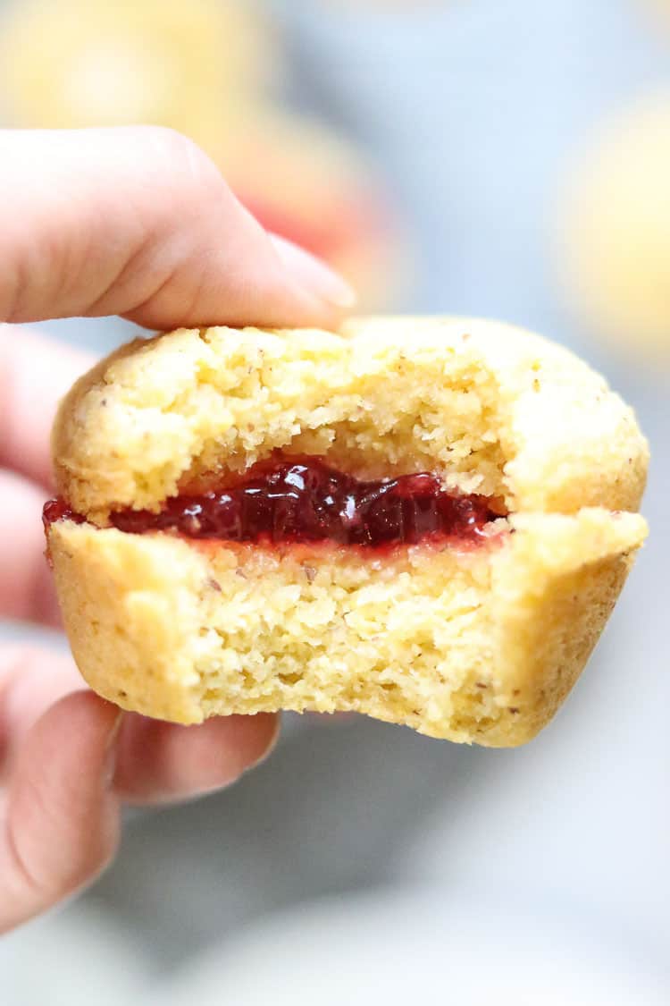 side closeup view of vegan cornbread muffin sliced with jam