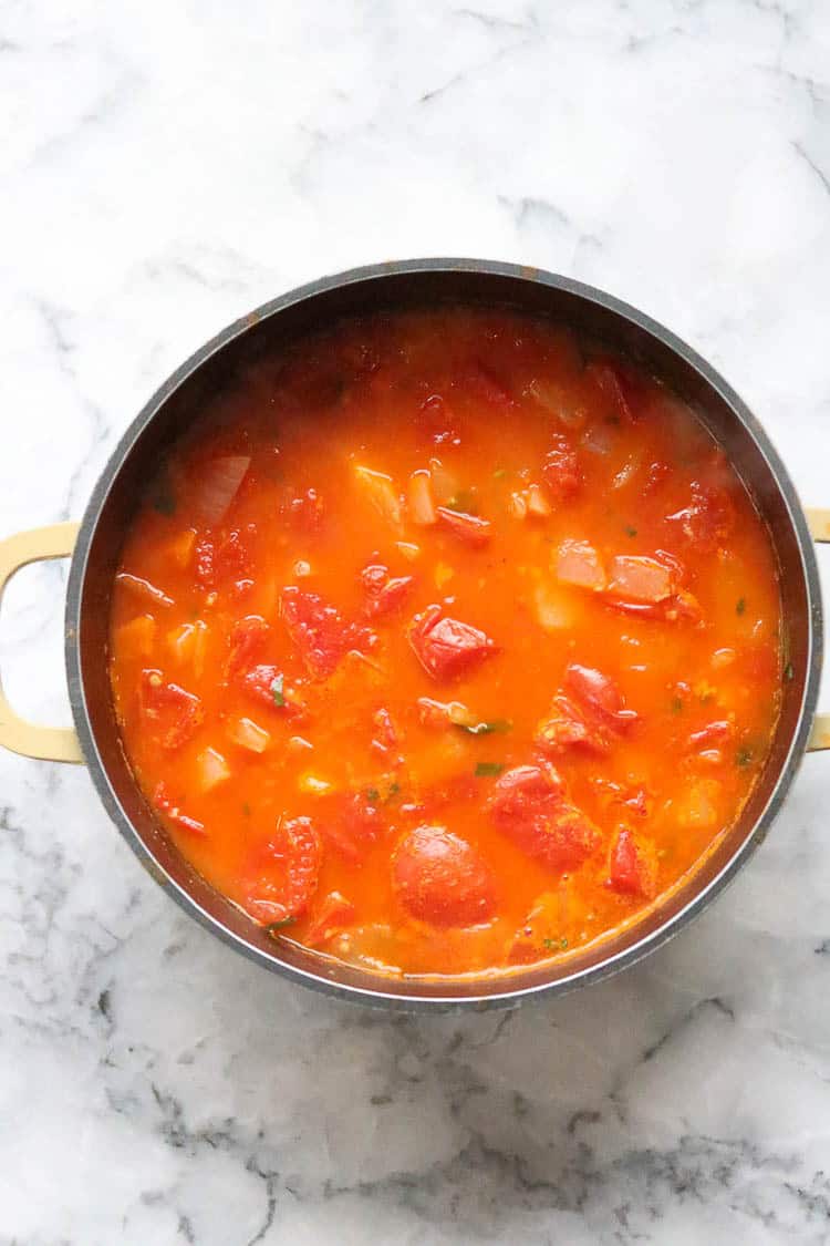 overhead shot of vegan tomato soup ingredients in a fully cooked state in a stockpot