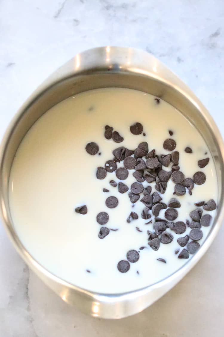 overhead shot of chocolate chips and non-dairy milk in small saucepan 