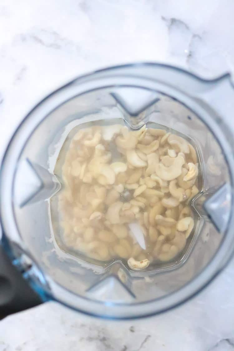 overhead shot of cashews and water in blender