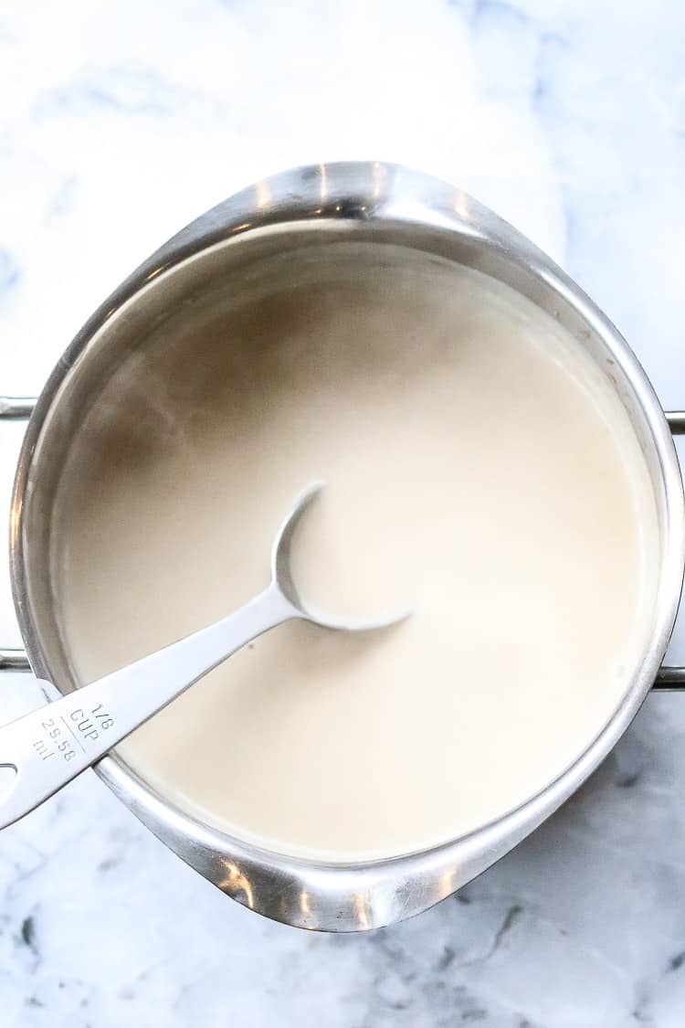 overhead shot of steaming vegan gravy with serving spoon