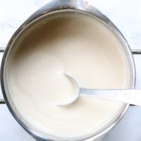 overhead shot of thickened cashew gravy in a silver pot