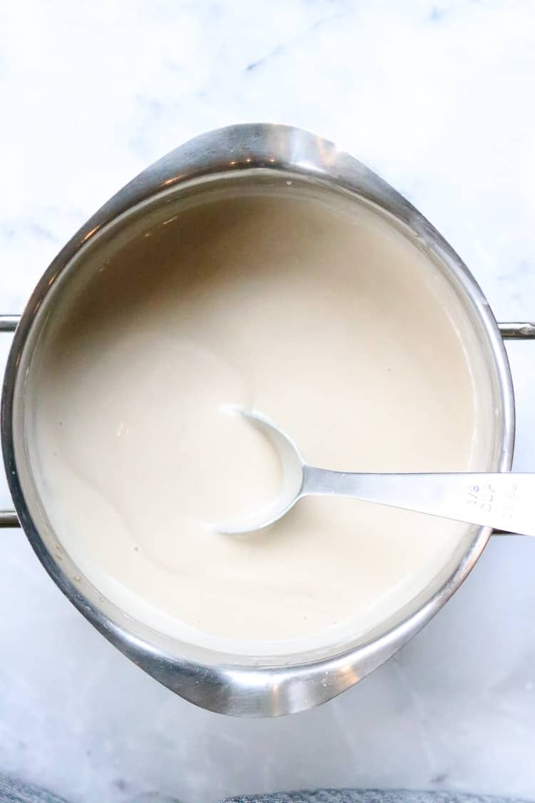 overhead shot of thickened vegan gravy in silver pot