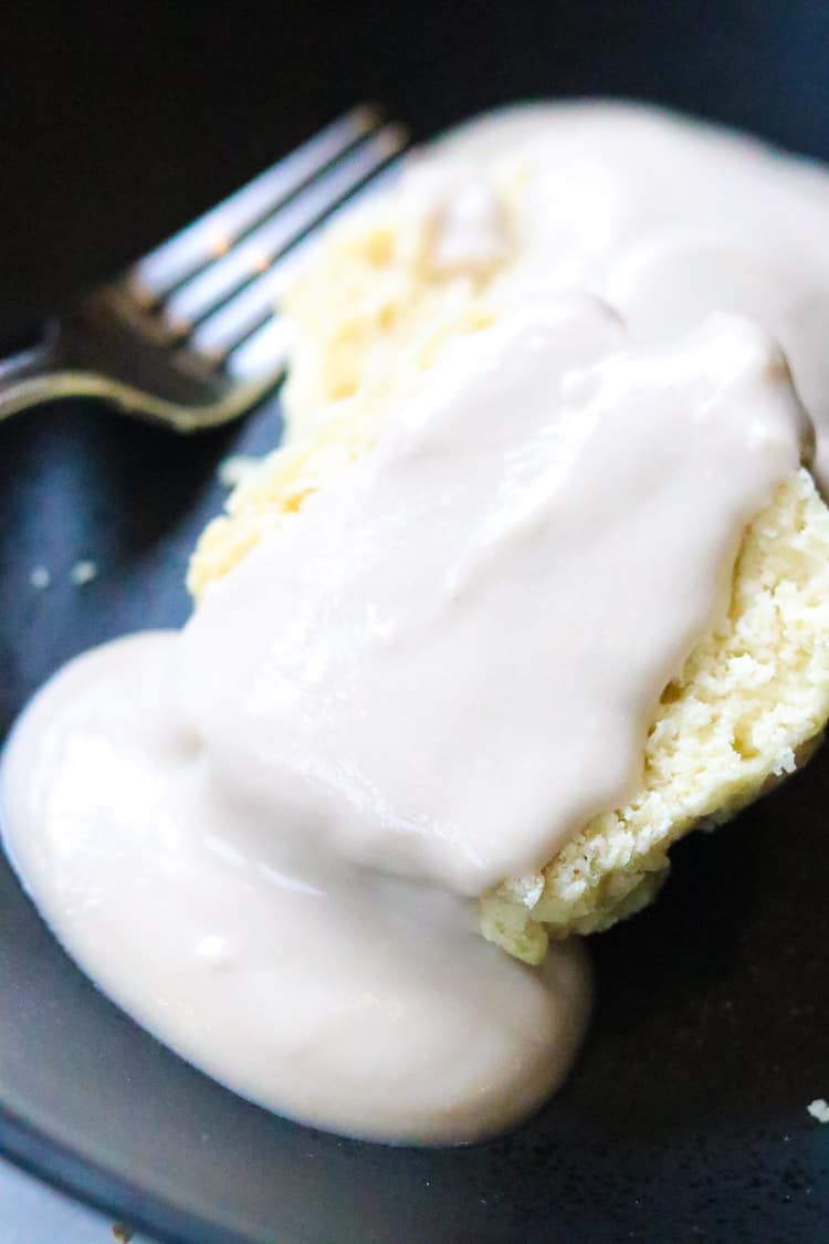 Vegan biscuit and gravy on a black plate