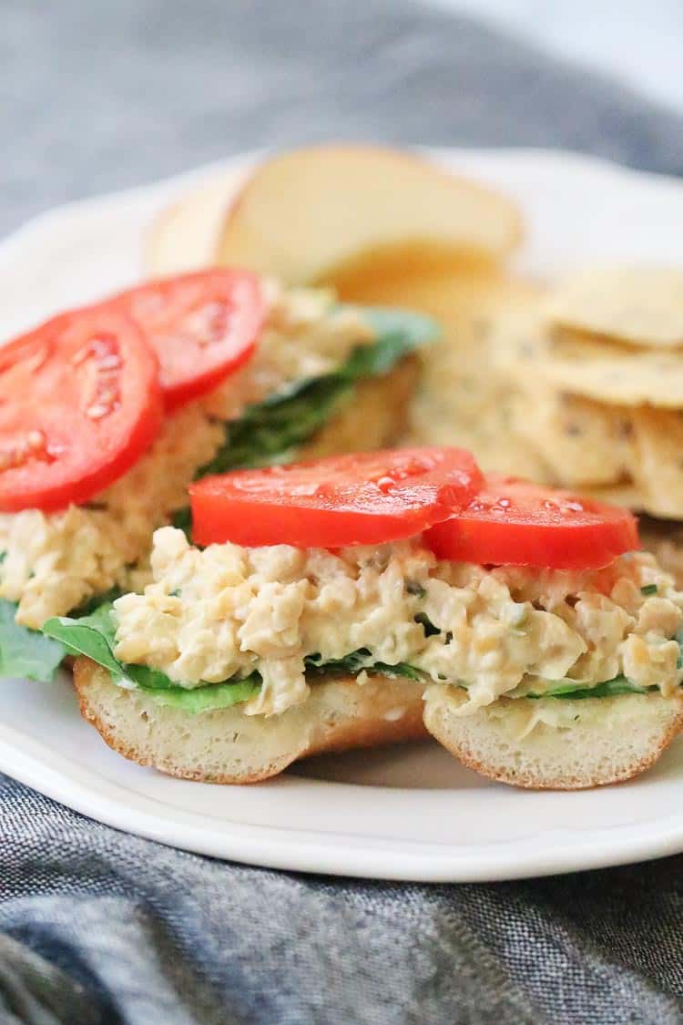 side closeup shot of vegan chickpea salad sandwich with tomato and lettuce