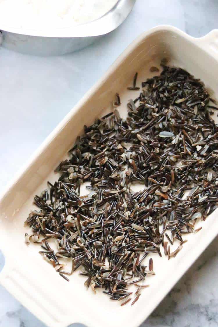 overhead shot of wild rice spread in the bottom of a casserole dish