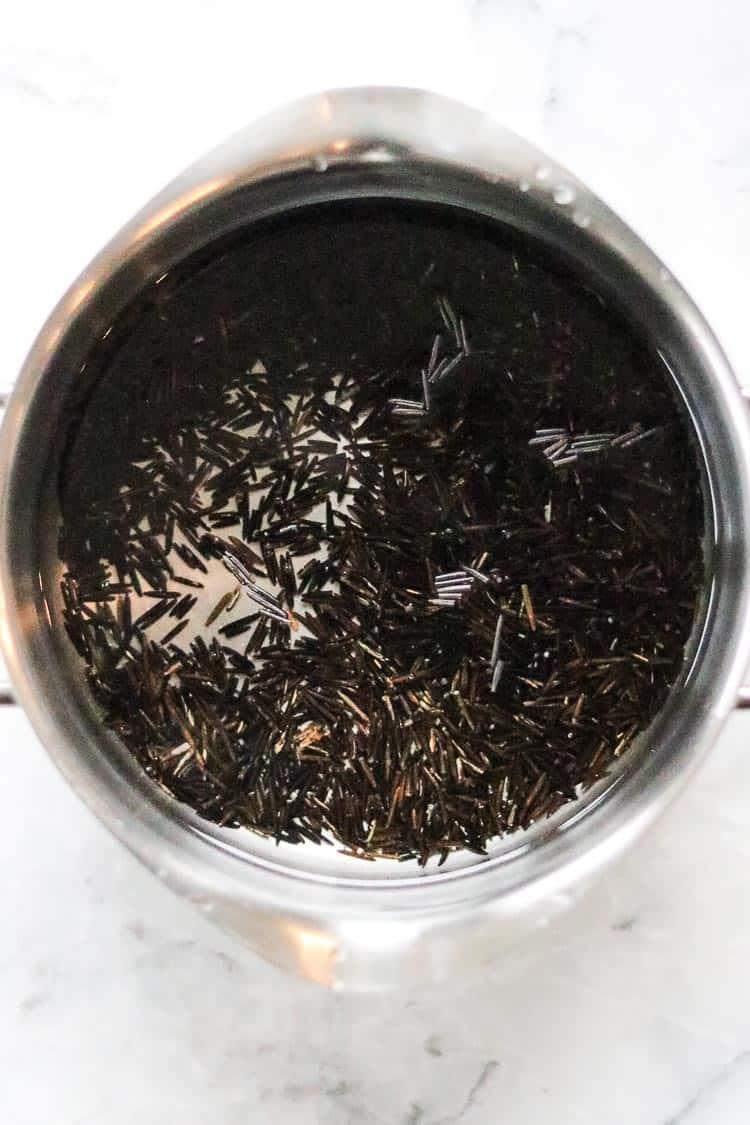 overhead shot of wild rice for casserole in a silver pot with water