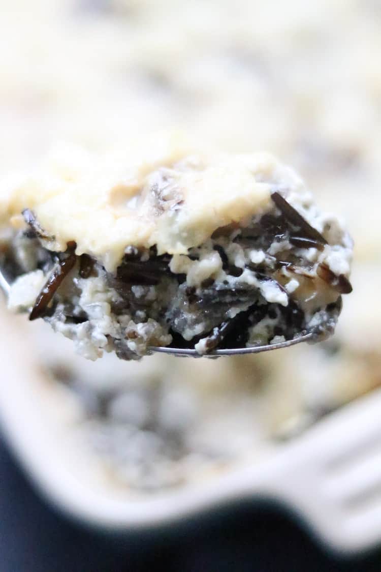 side closeup shot of a serving spoon full of wild rice casserole