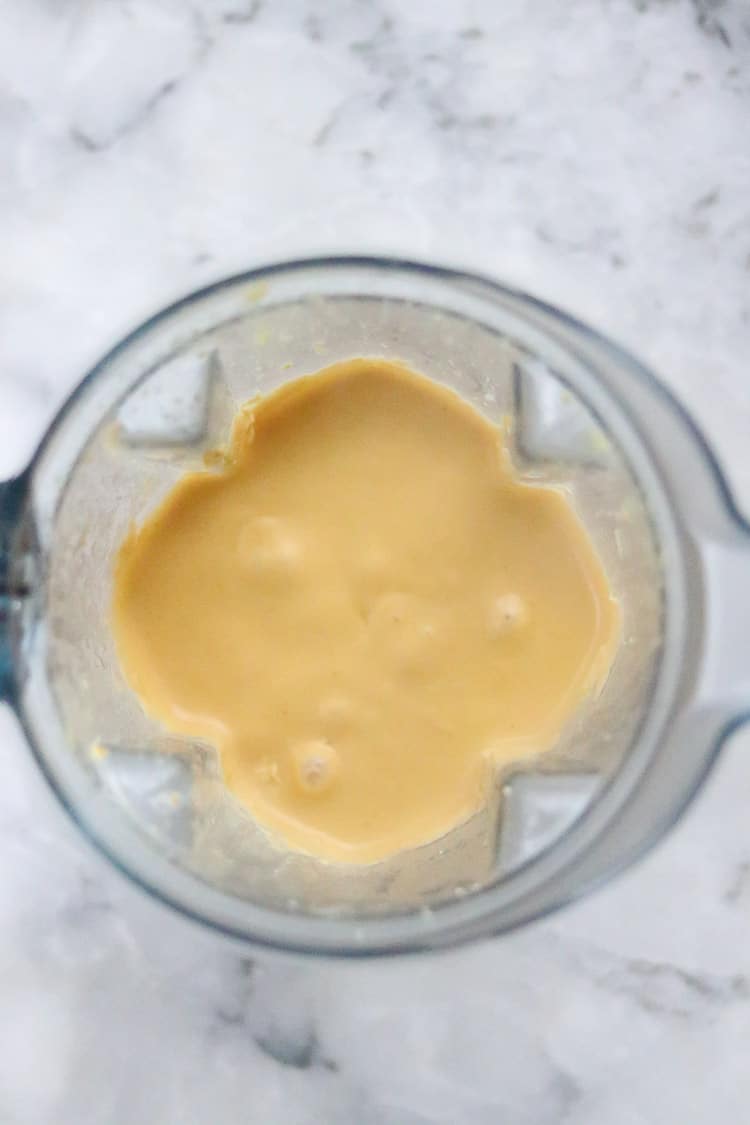 overhead shot of vegan cheddar cheese blended up smooth in blender
