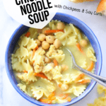 overhead shot of vegan chicken noodle soup in a blue bowl with text overlay for pinterest graphic