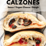 side closeup shot of stacked vegan calzones wrapped in a striped napkin with text overlay for pinterest