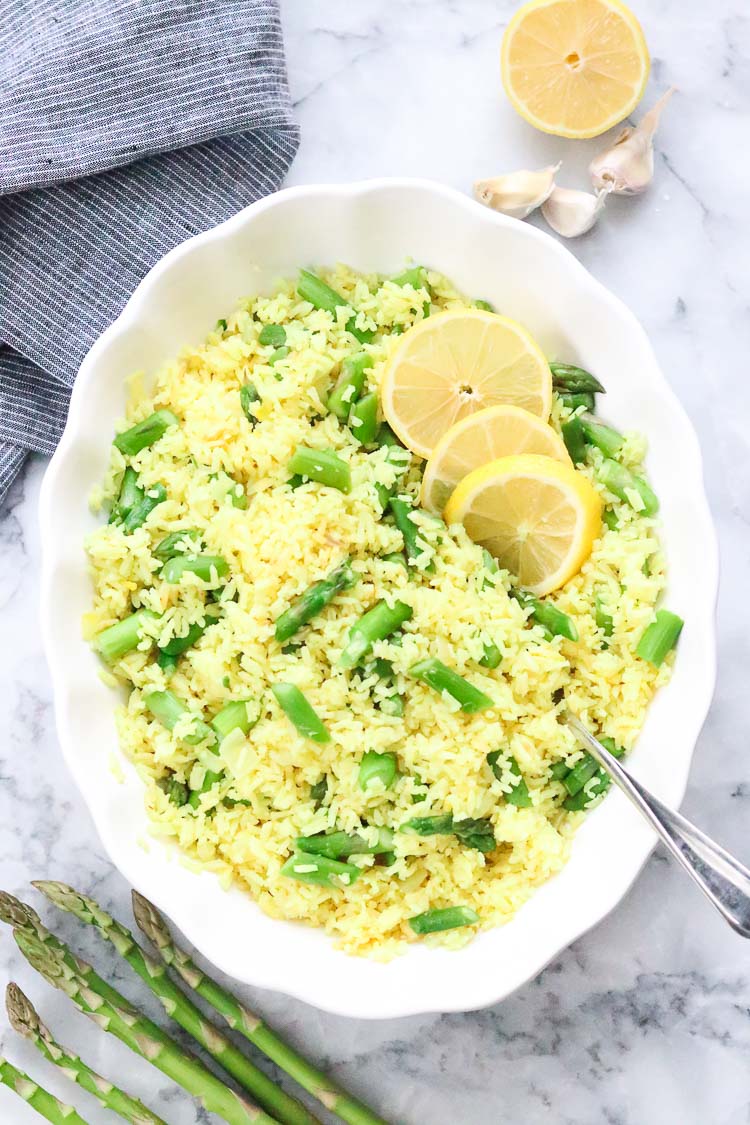 overhead shot of large white serving bowl filled with lemon rice and asparagus 