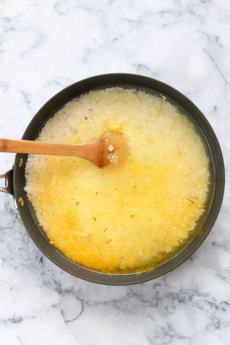 overhead shot of rice and other ingredients for lemon rice added to skillet