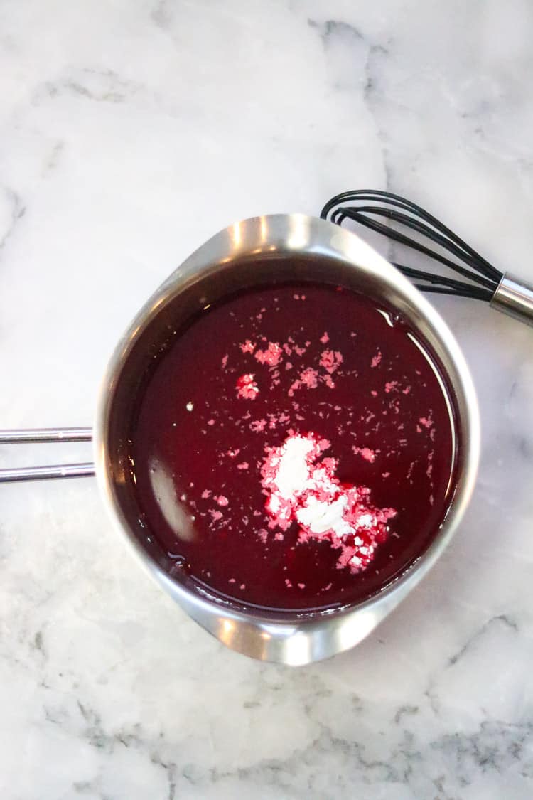 cornstarch and raspberry juice in a small saucepan with whisk beside