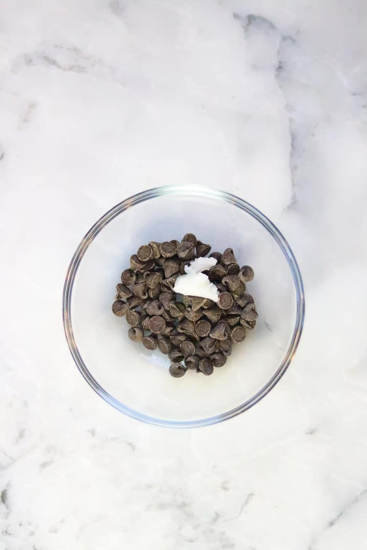 vegan chocolate chips in a clear bowl with coconut oil