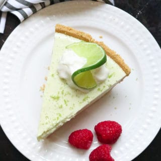 overhead shot of vegan key lime pie on a white plate and a black background