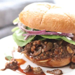 closeup side shot of vegan mushroom sandwich on a white plate