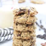side closeup shot of stack of vegan oatmeal chocolate chip cookies with non-dairy milk in background