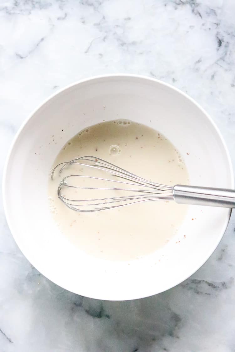 overhead shot of white bowl with vegan milk/egg mixture for vegan scones