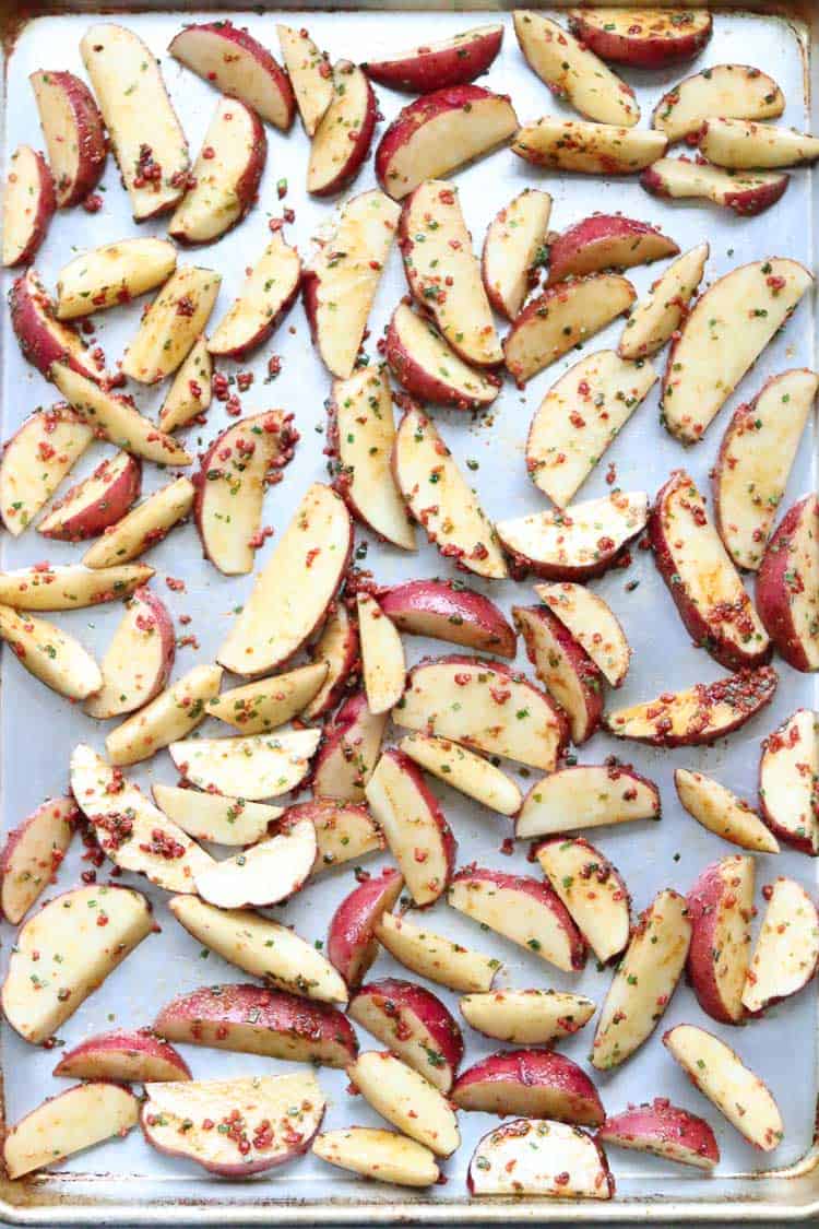 overhead shot of potato wedges spread out on a baking tray