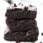 side shot of vegan avocado brownies stacked three high with text overlay for pinterest