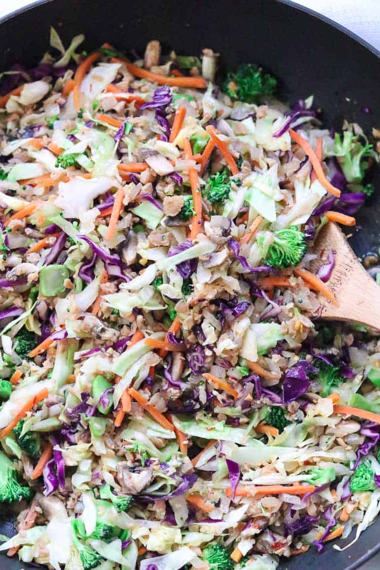 closeup overhead shot of vegan egg roll contents in a black frying pan