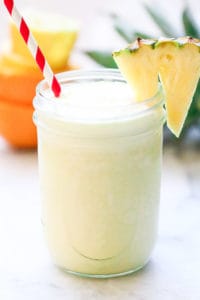 side shot of virgin pina colada with coconut milk in a mason jar with striped straw and pineapple slice