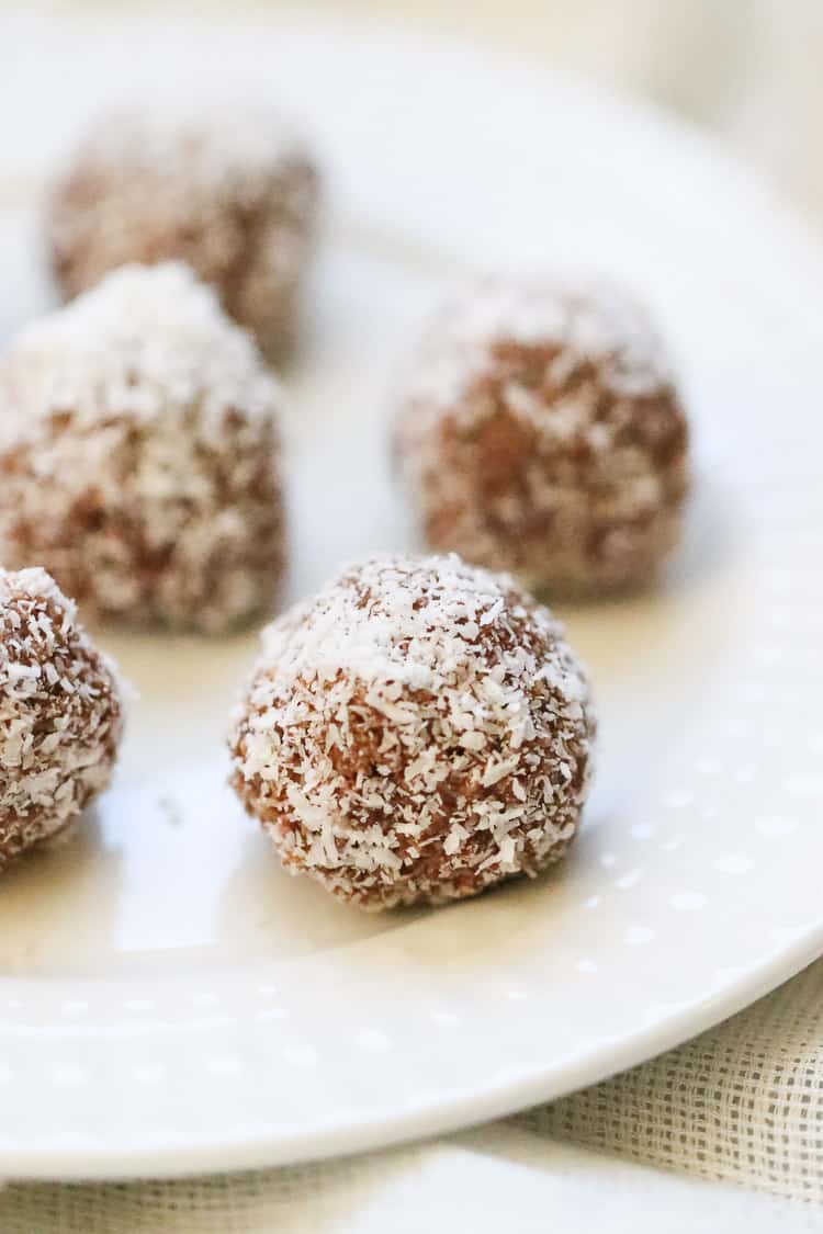 side overhead shot of vegan coconut balls placed on a white plate