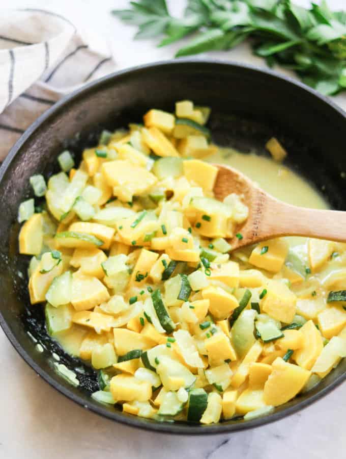 side overhead shot of vegan yellow and zucchini squash in a black skillet