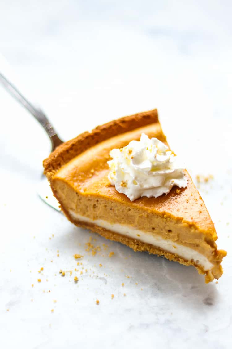 side overhead view of a slice of vegan pumpkin cheesecake on a marble background